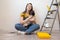 Independent young woman with pug dog planning renovation apartment sitting on floor with construction tool. diy repair