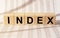 Index word on wooden cube blocks on financial background