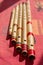 India, Five north Indian bamboo flutes on a red table.