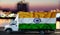 India flag on the side of a white van against the backdrop of a blurred city and river. Logistics concept