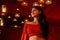 India girl long hair in red blouse stang lighting diyas in dark room