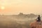 India, Hampi - December 22, 2015: A man is practicing yoga on the top of the cliff during the dawn