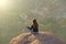 India. Hampi - February 2, 2018. A girl in a lotus position sits with her back against the background of sunrise or sunset.