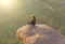 India. Hampi - February 2, 2018. A girl in a lotus position sits with her back against the background of sunrise or sunset.