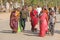 India, Hampi, February 2, 2018. A group of people, men and women in the saris, walk along the street of Hampi village. Hampi,