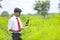 Indian agronomist collecting some information in smart phone at field