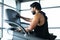 Indian athlet or bodybuilder running on treadmill by listening music at gym - concept of weight loss, burning calories