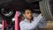 Indian auto mechanic working under car on hydraulic lift in garage