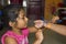 Indian baby girl tying a friendship band to her friend