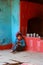 Indian barefoot boy in worn out poor clothes sitting on stone floor in outdoor traditional asian kitchen on 10.22.2017 in Dwarahat