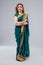 Indian beautiful fashion brunette woman in green traditional wedding rich sari with gold jewelry set nose ring piercing