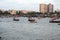 Indian boats on the water with cityscape in the background zoomed in