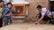 Indian boys realigning sand with a trowel at street in Jodhpur.