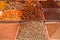 Indian bright colored powders and spice seeds in square metal trays on the counter