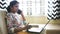 An Indian business woman working from home sitting on a sofa and talking on phone