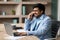 Indian businessman engaging in conversation on phone working online indoor