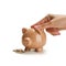 Indian clay piggy bank with human hand finger dropping coin on white background