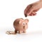 Indian clay piggy bank with human hand finger dropping coin on white background