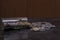 Indian coins falling from a glass bottle on a black wooden table