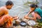 Indian couple clean fish on the river