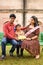 Indian couple posing for maternity baby shoot with their 5 year old kid. The couple is posing in a lawn with green grass and the