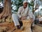 An indian craft old man making dry grass chair making task at agriculture field in india oct 2019