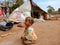 an indian cute little poor kid girl crying outside the huts at soil field,  hungry baby in India January 2020