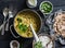 Indian dhal in cooking pan with jasmine rice, coriander and whole grain flatbread on dark background, top view. Flat lay