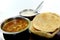 Indian dish spicy Chick Peas curry also known as Chola/Chana Masala or commonly Chole, served served with fried puri