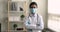 Indian doctor wear coat facemask standing indoor with arms crossed