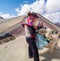 Indian dressed in bright colors feeds llama at the seven colors mountain