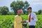indian farmer and banker standing at field