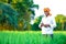 Indian farmer holding crop plant in his Wheat field