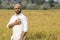 Indian farmer with paddy barley in his pocket connecting earning from yield