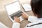 Indian female doctor typing using laptop mock up white screen at desk, close up.