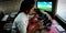 An indian female lab technician looking into microscope at laboratory