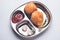 Indian food snack Kachori or Kachodi served in a stainless steel plate with tomato ketchup