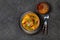 INDIAN FOOD. Traditional KERALA FISH CURRY with naan bread, gray plate, black background