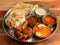 Indian Gavkari Chicken Thali / food platter consists variety of veggies,Chicken meat, lentils,rice, sweet dish, snacks etc.,