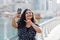 An Indian girl takes a selfie on her phone while walking along Dubai Marina