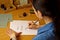 Indian girl writes with ink pen on a white paper sheet. stationery on a wooden desk. spelling lessons and caligraphy exercises.