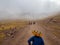 Indian group with traditional clothing walks in front of fog covered mountain range