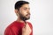 Indian guy in white background using microneedling for beard growth