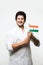 Indian handsome boy or man in white ethnic wear holding indian national flag and showing patriotism, standing isolated over white