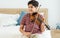 Indian handsome teenage boy, playing, practicing violin musical instrument with happiness in bedroom at cozy home in leisure time