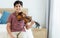 Indian handsome teenage boy, smiling, playing, practicing violin musical instrument with happiness in bedroom at cozy home in