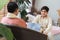 Indian handsome teenage son and father with traditional clothing sitting on sofa talking having conversation, smiling spending