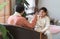 Indian handsome teenage son and father with traditional clothing sitting on sofa talking having conversation, smiling spending