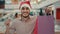 Indian happy Hispanic guy man in Santa X-mas Christmas hat in shopping mall looking camera showing holding money cash