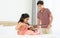 Indian happy teenage boy, girl sibling teaching, learning, playing, practicing violin musical instrument together at cozy home in